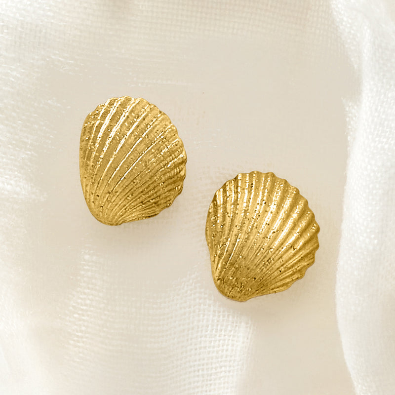 Ridged gold seashell stud earrings, close-up view of shell shape and shine