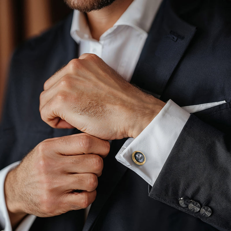 Hematite intaglio cuff link in 14kt yellow gold on shirt cuff, round dark face