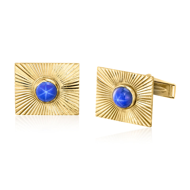 Gold-tone square cuff links with blue star sapphire cabochon and textured sunburst frame
