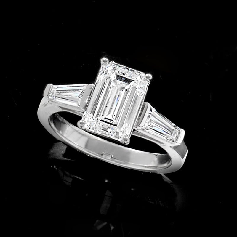 Platinum diamond ring with emerald-cut center, four-prong setting and baguette side stones