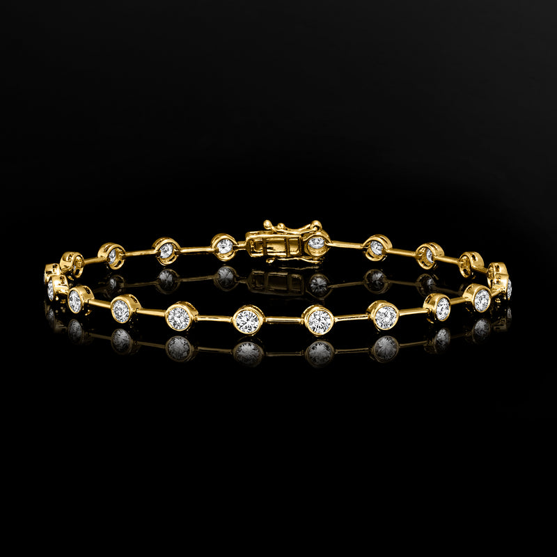 Yellow gold station bracelet with round diamond links and a bezel-set baguette center