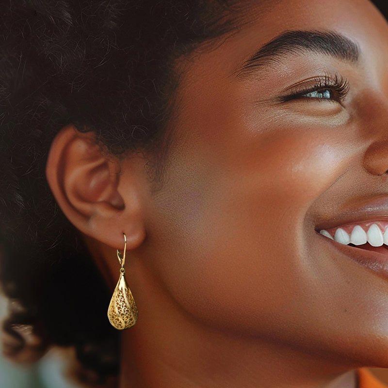 Gold filigree teardrop earrings on model, leverback drop profile at ear.