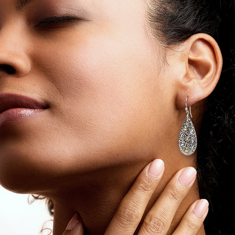 Teardrop earrings on ear: sterling silver with yellow gold inlay details