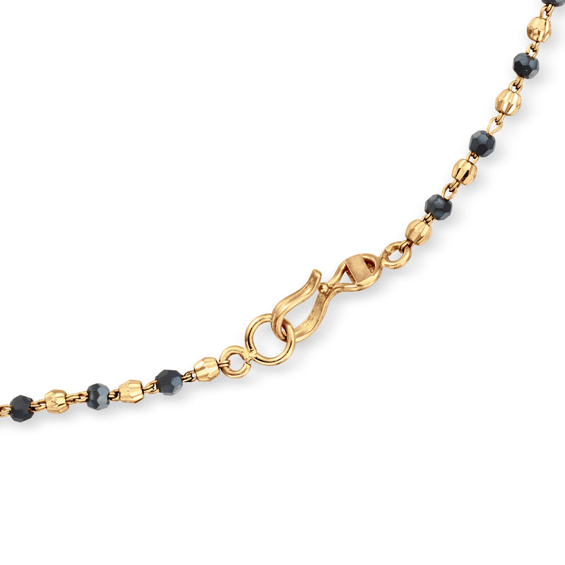 Close-up of vintage yellow-gold bead necklace clasp with dark accent beads