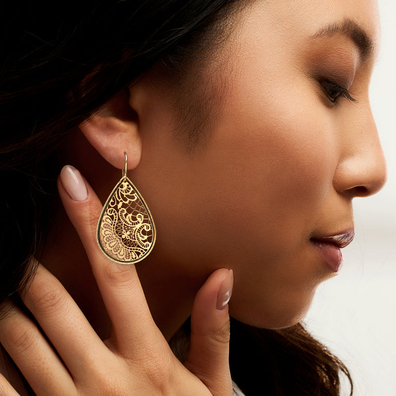 14kt yellow gold teardrop earrings with floral filigree lace, close-up on model's ear