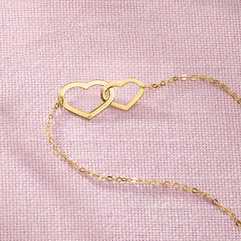 Yellow gold infinity heart bracelet close-up of double heart links on chain