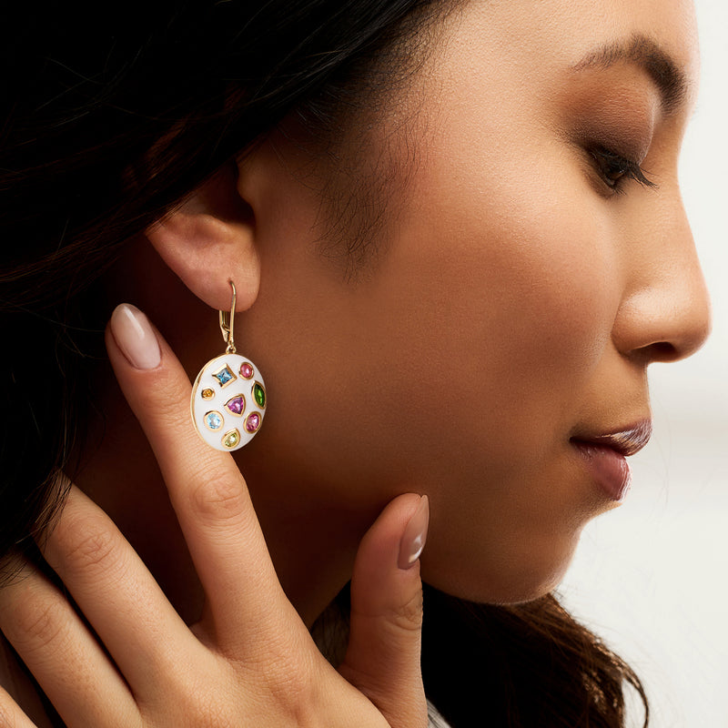 Gold leverback drop earrings featuring a white enamel round with multi-color stones