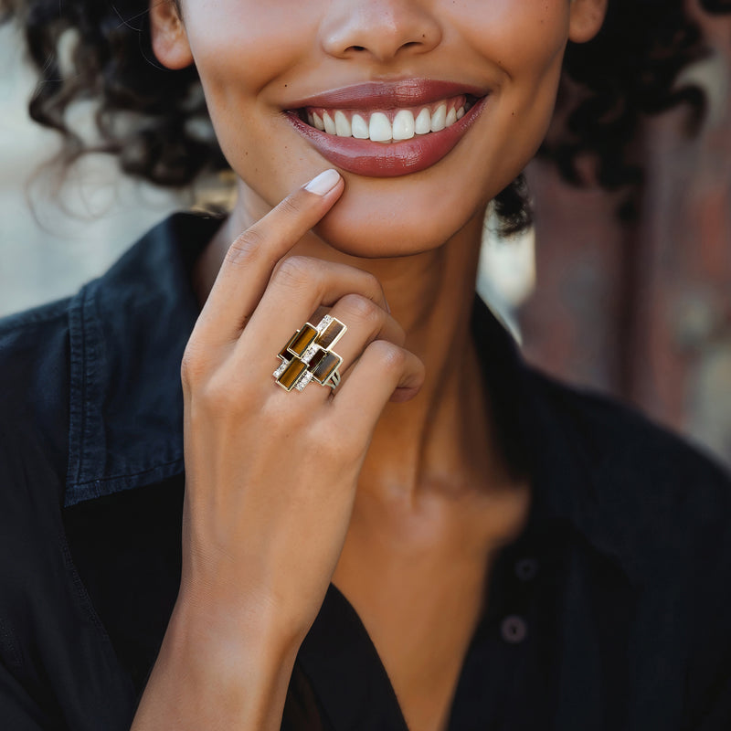 Yellow gold tiger eye and diamond cocktail ring worn on a finger