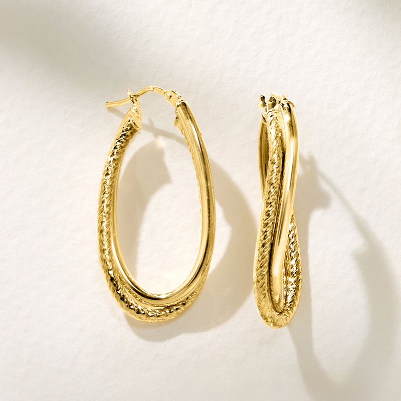 Yellow gold double-oval twisted hoop earrings with textured side profile