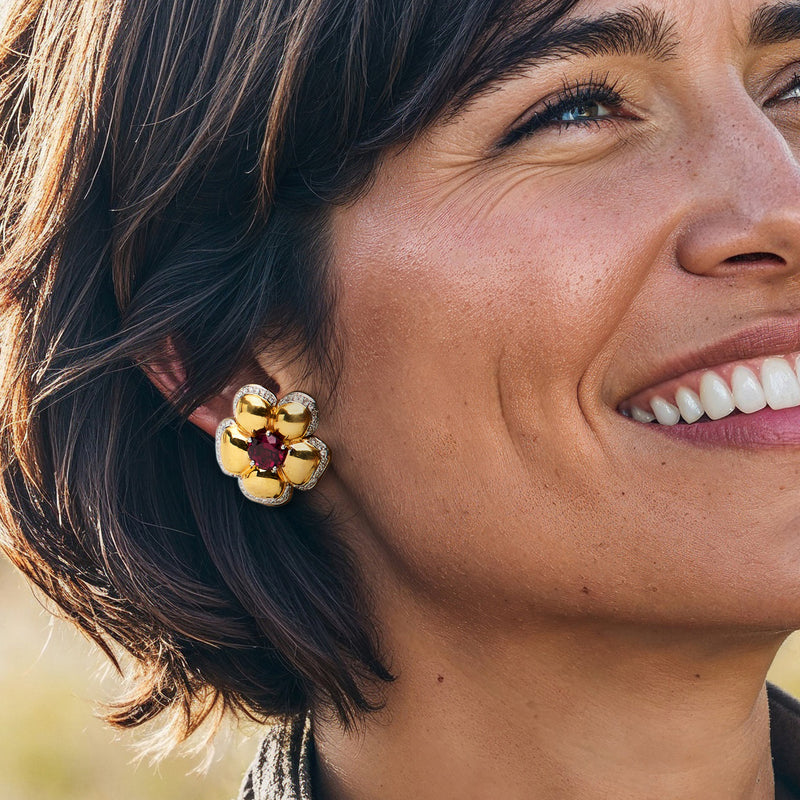 Yellow gold flower earrings with red gemstone center, diamond-trimmed petals