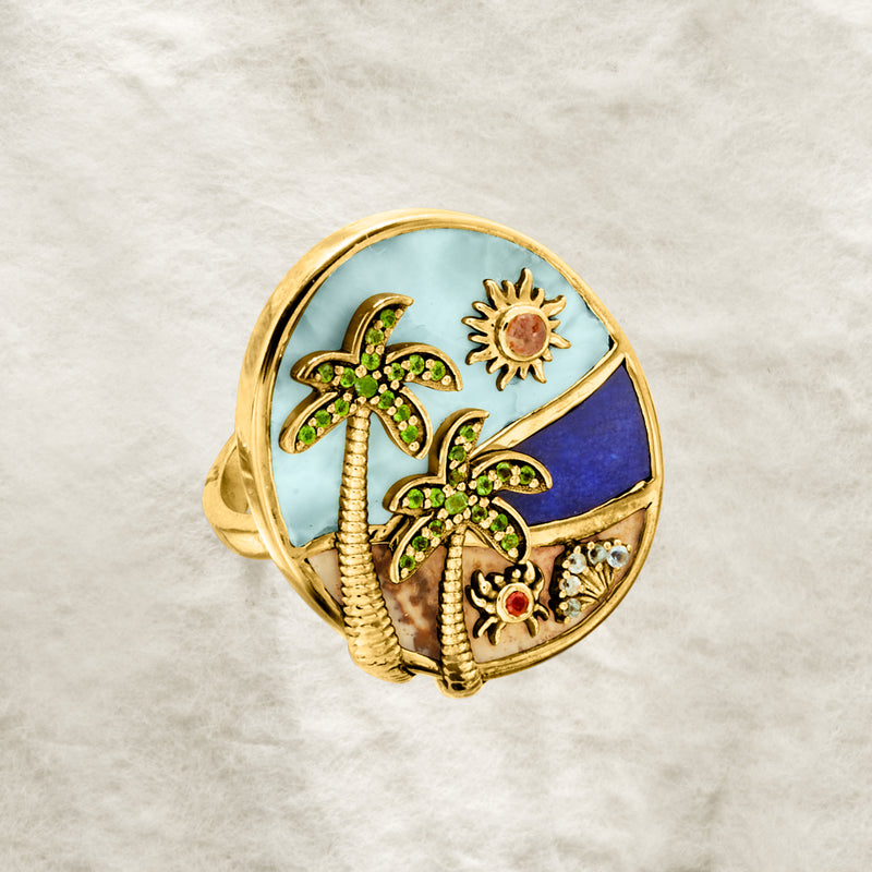 Gold-tone oval beach ring with palm trees, sun and shell motifs, gemstone centers on band
