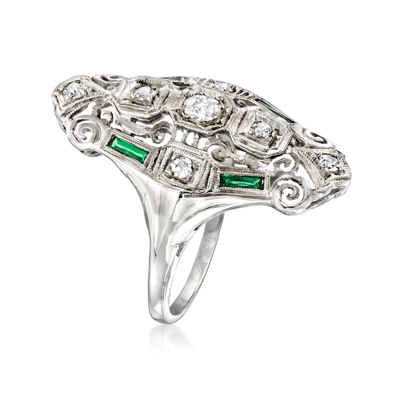 White gold ring featuring diamond clusters and two green gemstone insets
