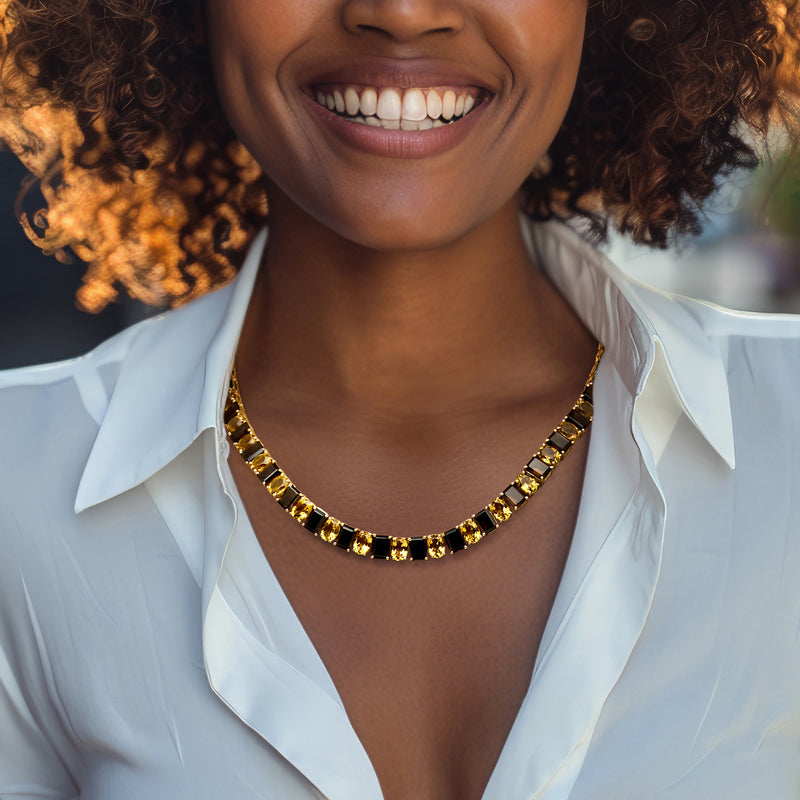 Gold-tone gemstone tennis necklace with dark and yellow rectangular stones at neckline