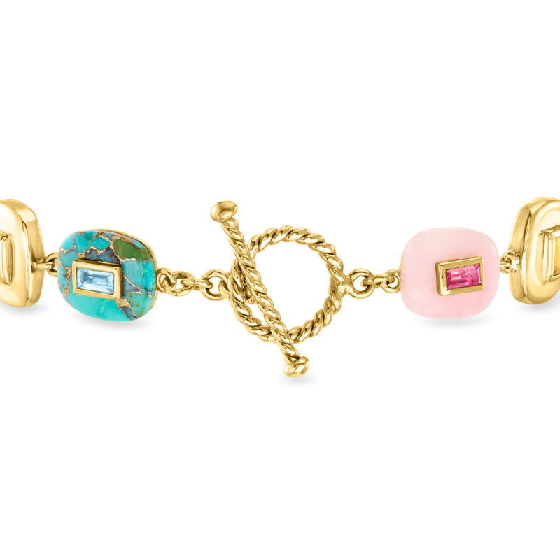 Gold-tone bracelet with turquoise oval bezel stones, pink squares, and hinged clasp