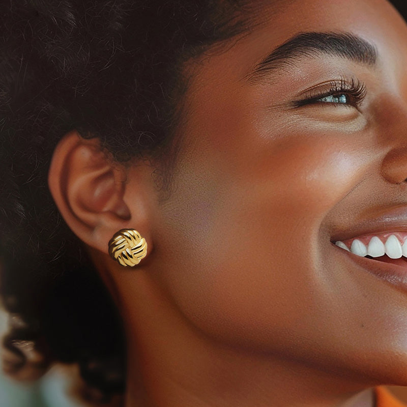 Gold knot stud earring on ear, round braided love-knot design