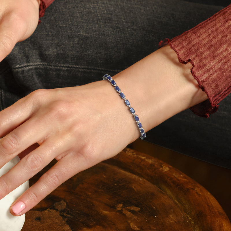 Sterling silver sapphire bracelet on wrist with blue stones and diamond highlights