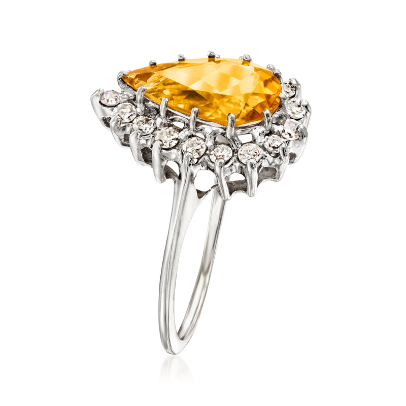 Pear-cut citrine ring in white gold with raised prongs and diamond halo.