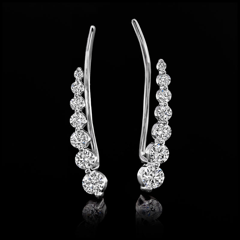 Graduated diamond ear climber earrings featuring alternating stone sizes on curved prongs