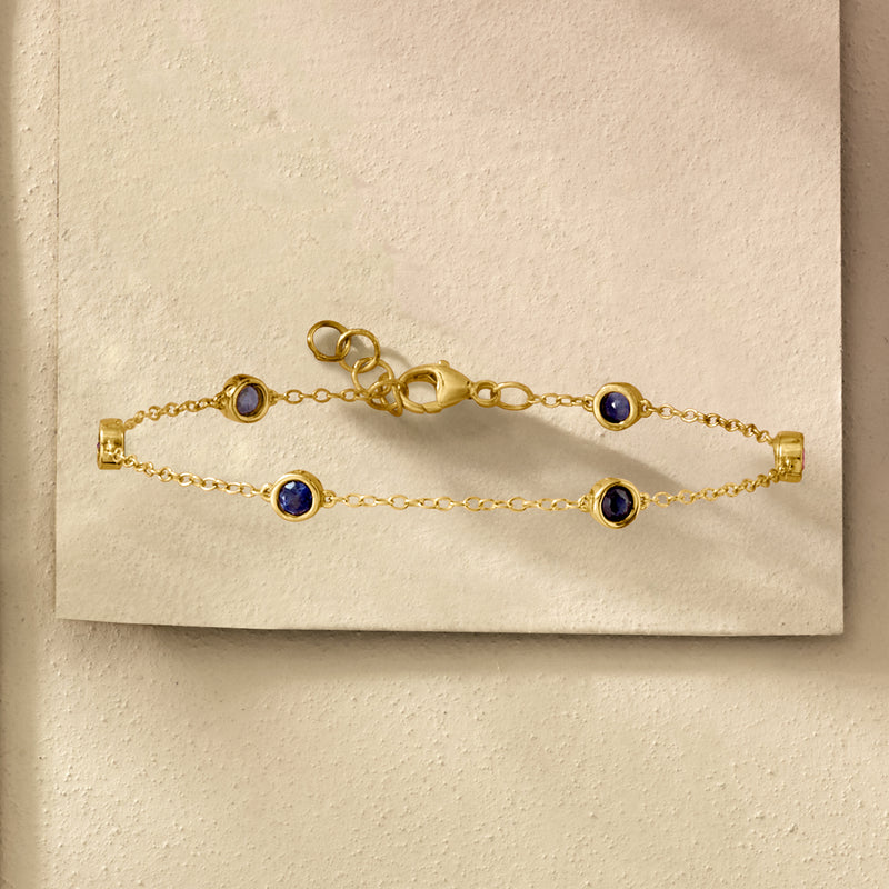 Gold station bracelet with round blue sapphire stations and toggle clasp