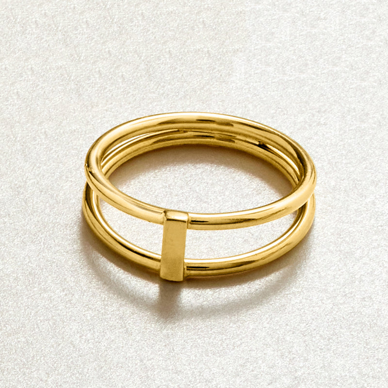 10kt yellow gold open-space bar ring on textured surface, stacked bands with bar