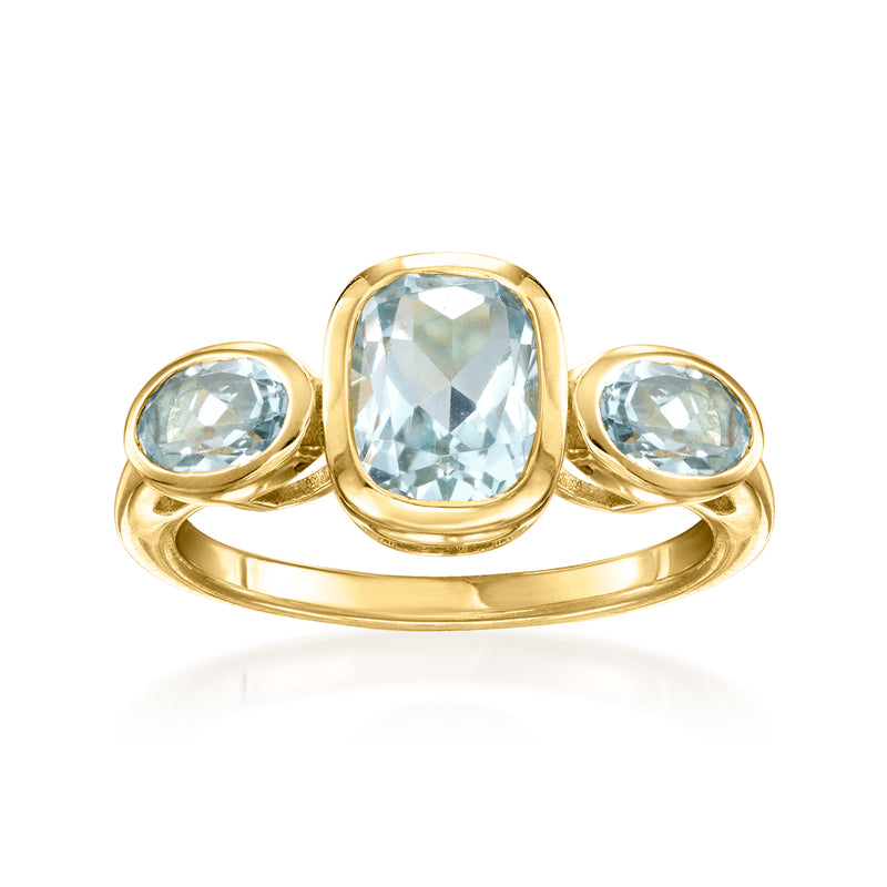 Gold three-stone ring with sky blue topaz: oval center and two oval side stones, bezel set