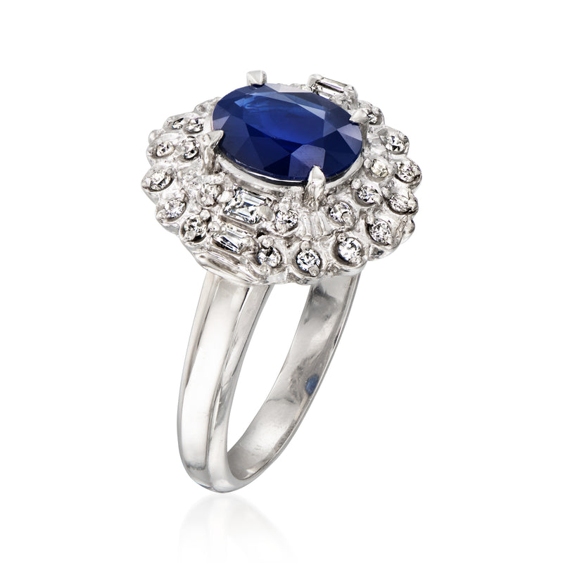 Platinum ring with oval blue sapphire center and raised diamond cluster setting