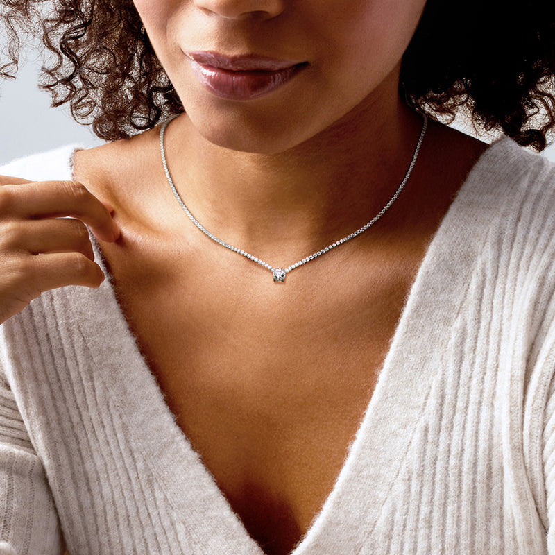 Sterling silver CZ tennis necklace on model, round solitaire-style pendant at center
