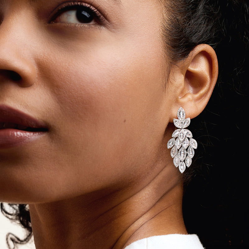 Diamond leaf drop earrings in white gold on model's ear