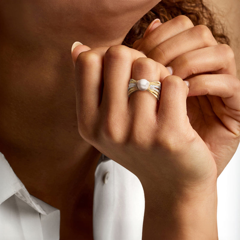 Cultured pearl multi-row ring in gold with diamond inlays, worn on hand; white pearl.