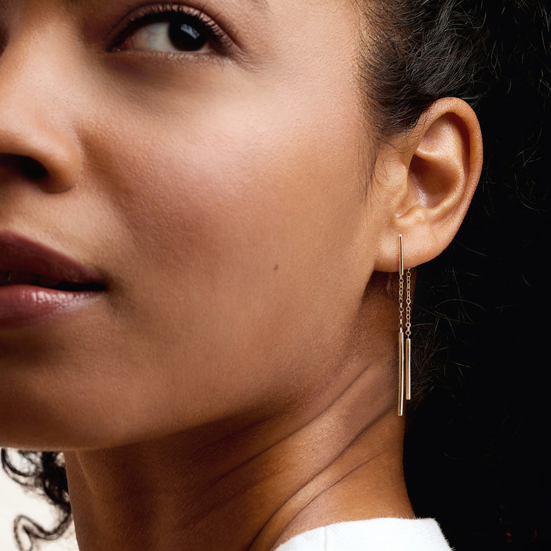 10kt yellow gold drop earring with slim linear bar and dangling chain on ear