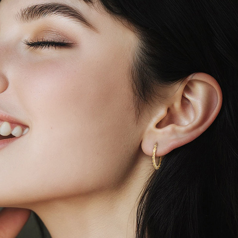 Yellow gold rope-chain hoop earrings on model, small round textured hoops