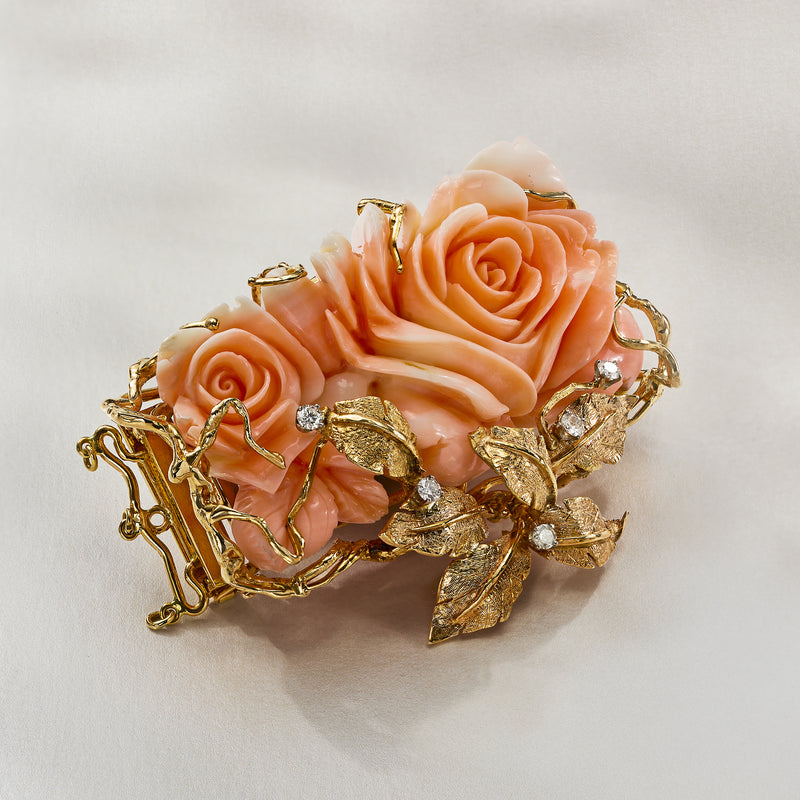 Vintage gold floral pin with three coral-pink roses, diamond-set centers, and leaf detailing
