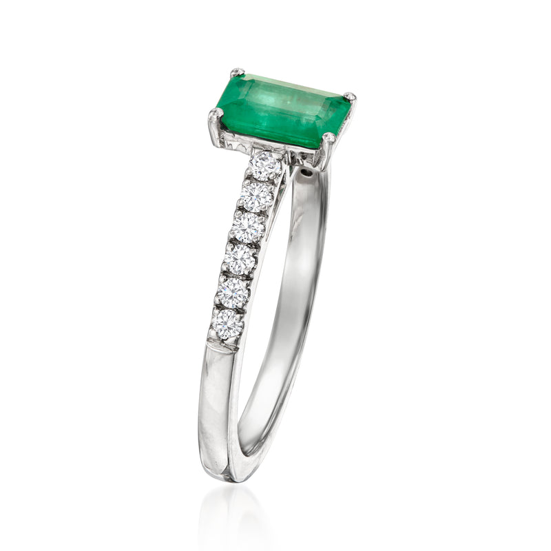 Platinum ring featuring an emerald-cut green gemstone with round diamond accents
