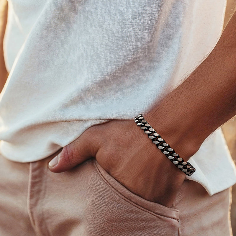 Men's black-and-silver Cuban-link bracelet worn on wrist
