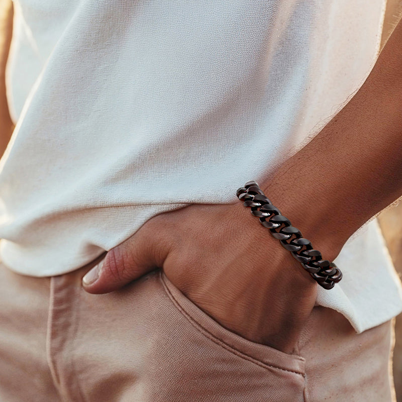 Matte black Cuban-link bracelet worn on wrist, hinged clasp near hand
