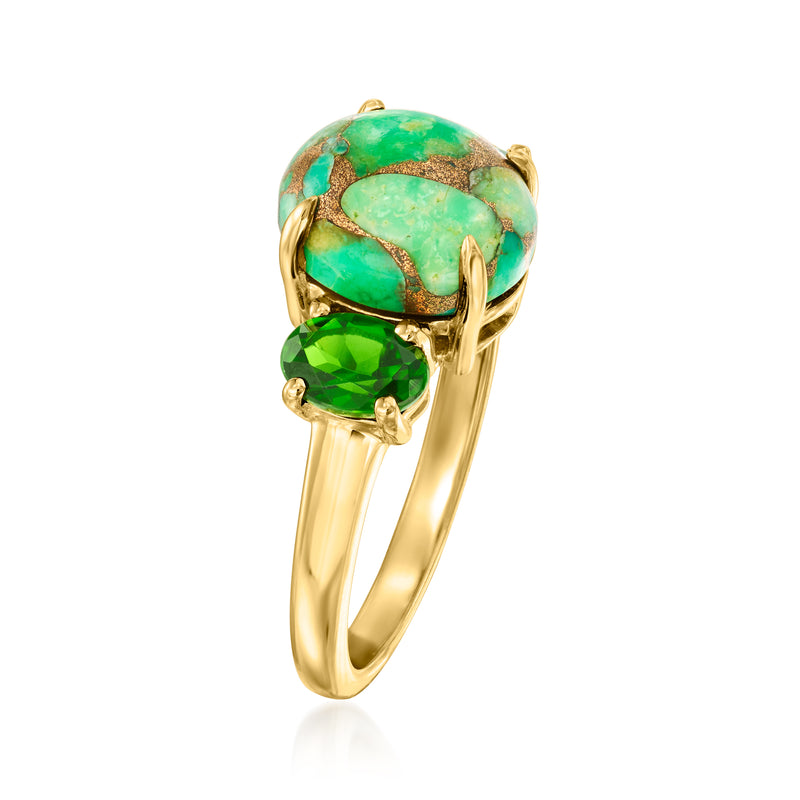 Gold-tone ring with oval turquoise center and green side stones, angled view