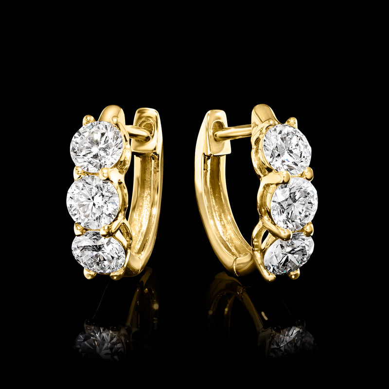 Yellow gold huggie hoop earrings with three round diamonds in a snug three-stone setting