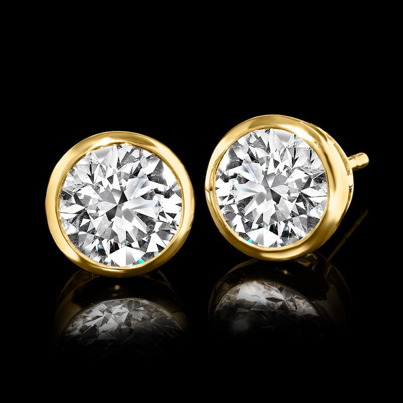 Bezel-set round diamond stud earrings in 14kt yellow gold, close-up