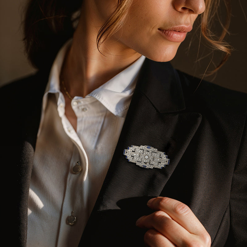 Diamond and blue sapphire pin on blazer lapel, rectangular filigree design