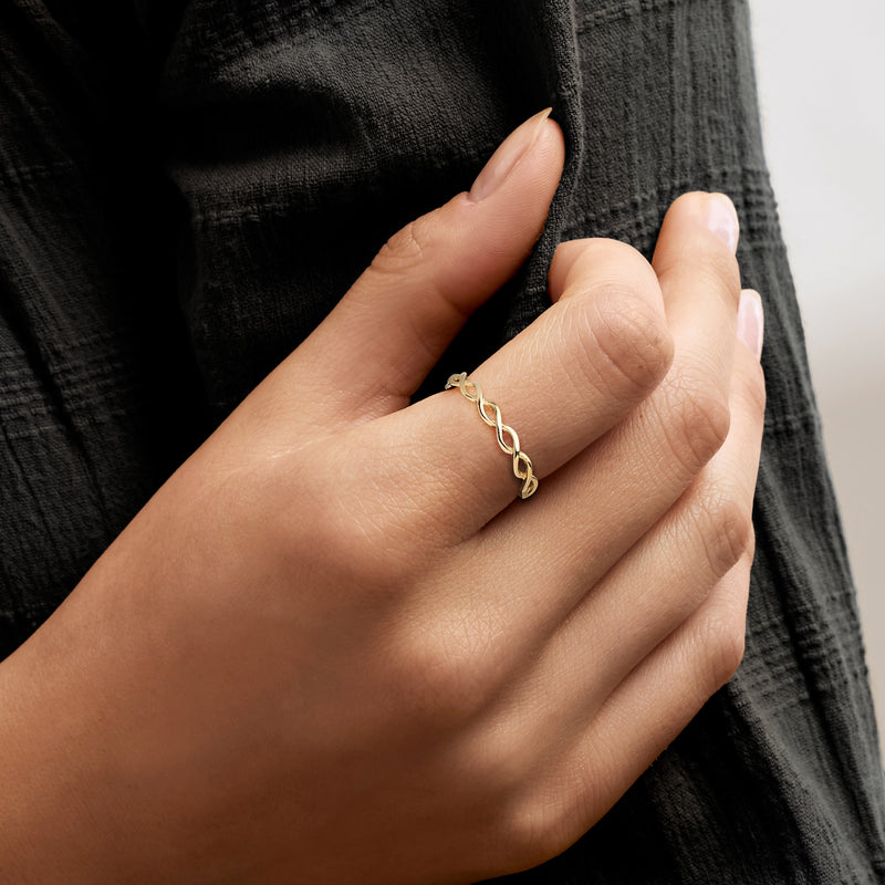 10kt yellow gold braided ring on finger with small rope-link band
