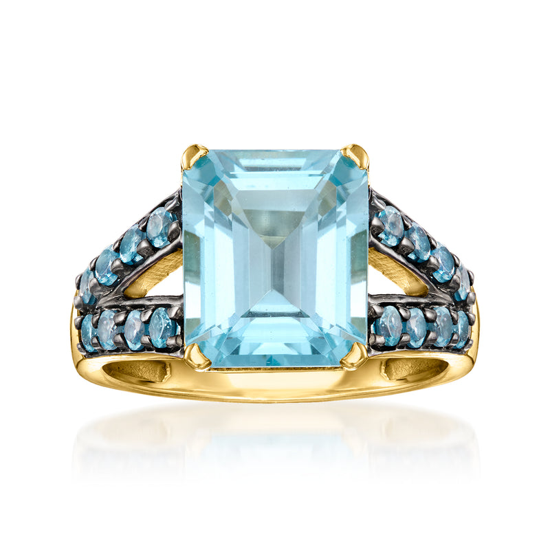 Gold-tone ring with large rectangular light-blue topaz center and blue gemstone side accents