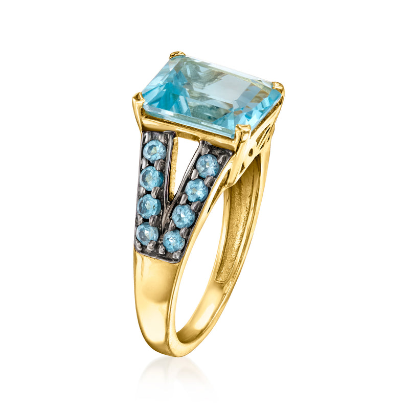 Gold-tone ring with rectangular light-blue topaz and clustered blue gemstone side details