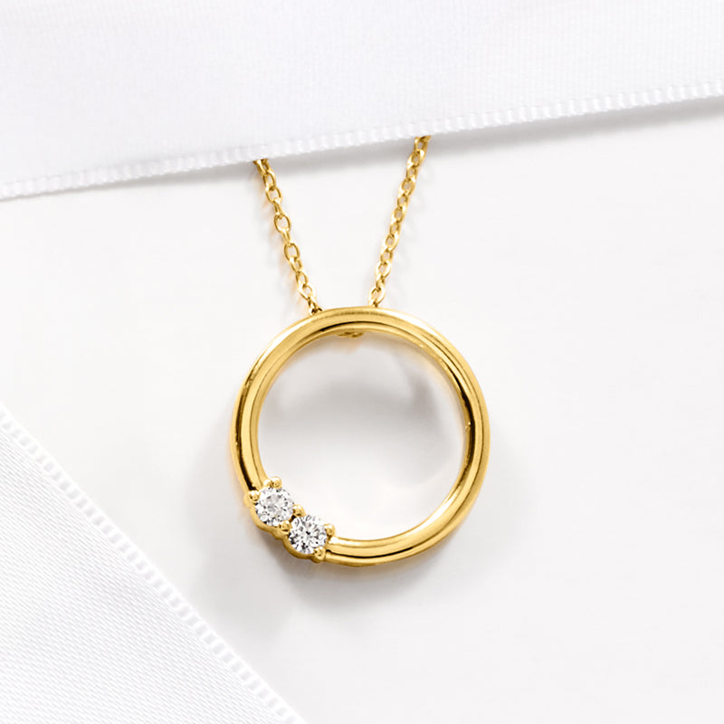 Gold circle pendant necklace with three lab-grown diamond stones and link chain.