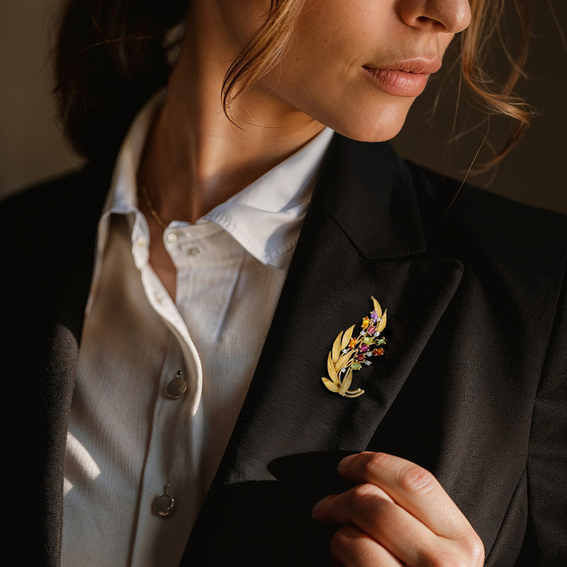 Gold floral lapel pin with multicolor gemstones and small diamond accents