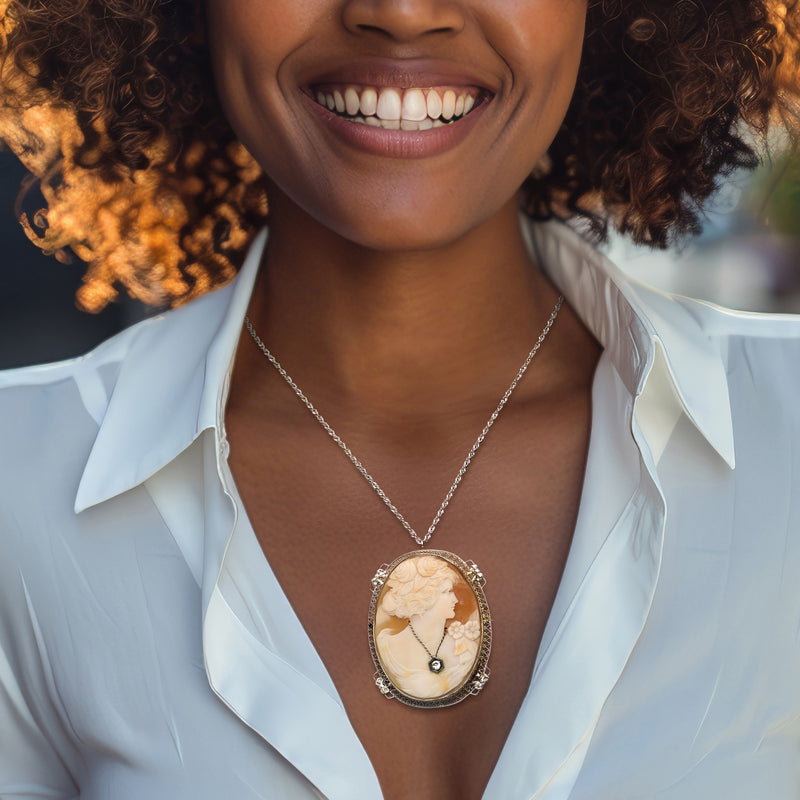 Shell cameo pendant in white gold with portrait profile and dark diamond, worn on necklace