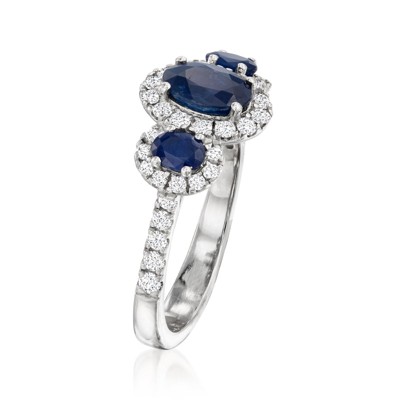 Platinum three-stone ring side view: oval blue sapphire center with diamond accents