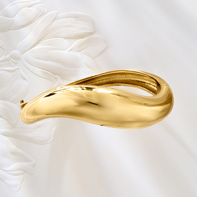 Gold bangle bracelet with sculptural oval curve, high-polish finish, and side clasp