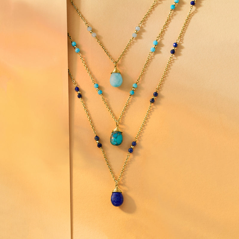Layered gold-tone necklace with multiple strands and blue/turquoise pendant drops