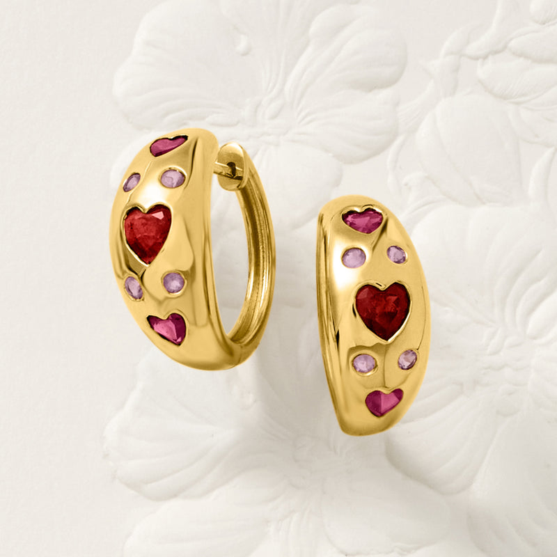 Gold heart-studded hoop earrings with red and purple heart gemstones on oval frames
