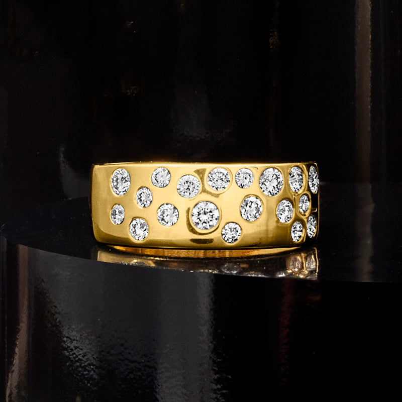 Wide gold diamond band with scattered round stones, reflective finish